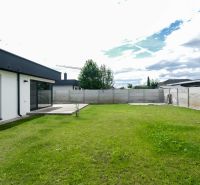 Garden at a family house in Košúty with a lawn and a concrete fence.