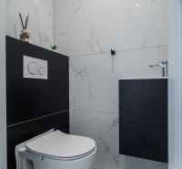 Bathroom in a family house with tiles and a concealed toilet.