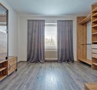 A room in a 3-room apartment with a floor featuring a wood decor.