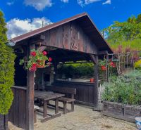 Garden gazebo with wooden benches and table in Dohňany.