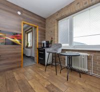 A kitchen with a wooden decor floor in a 3-room apartment.