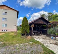 Dohňany: A yard with a wooden gazebo near a three-story building. Lawn area and flowers.