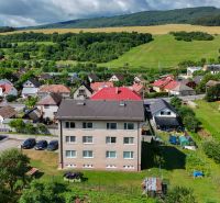 A top view of part of the village Dohňany with apartment buildings and surrounding greenery.