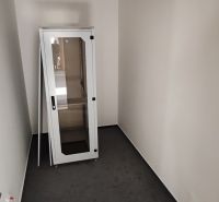 A small office room with a metal cabinet on a dark floor with a wood decor.