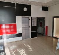 Office interior with an elevator, black and white wall, and a clock on the wall.