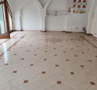 Empty commercial spaces with mosaic flooring and arched wall decor.