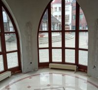 Commercial premises with large arched windows and mosaic flooring, overlooking the Courtyard of Europe in Komárno.