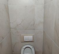 A restroom with tiled walls in commercial premises.