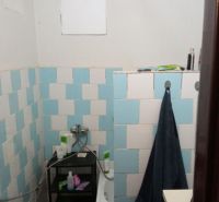 A bathroom in a building with a wooden ceiling and blue tiles.