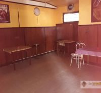 The interior of the building with wood-decor flooring, tables, and chairs.