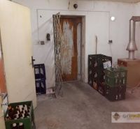 The interior of a building with beer crates and old doors, next to which there are doors.