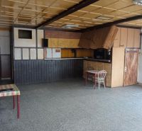 The interior of the building with simple furnishings and a stone-patterned floor.