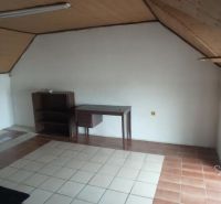 Interior of a building with a window, table, and wooden ceiling.