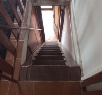 A staircase leading down with a brown floor in the building.