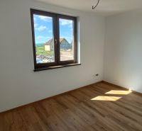 Interior of a family house with a wooden decor floor and a large window.