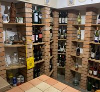 A wine cellar with brick shelves in a family house, full of wine bottles and decorations.