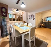 A dining room in a family house with a brick wall, wooden decor, and a fireplace.