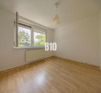 A room with a wooden floor decor and an open window in a 2-room apartment.