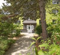 Entrance to the apartment building on Družstevná Street in Malinovo, surrounded by greenery.