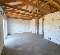 A building in a family house with exposed wooden beams and a concrete floor.