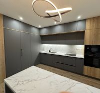 A kitchen in a family house with marble surfaces and a wooden decor floor.