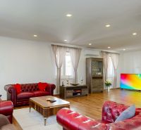 Living room in a family house with a fireplace, color TV, and a floor with a wooden decor.