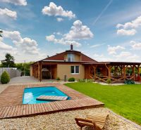 A family house on Lehota Street in Lehota with a pool and a terrace surrounded by a green lawn.