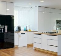 A kitchen in a family house with white cabinets and a wooden decor floor.
