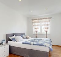 Bedroom with a double bed, a nightstand, and a large window, Family house.