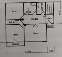 Floor plan of a family house with three rooms, a kitchen, two balconies, and a wardrobe.