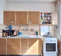 A kitchen in a family house with a gas stove and cabinets with a wood decor.