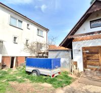 A family house on Štúrova Street in Ludanice with wooden garage doors and a trailer.