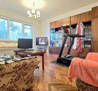 Living room in a family house with sofas, TV, and wooden decor flooring.
