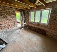 A room in a family house with brick walls and a large window.