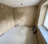 A room with bare walls and a concrete floor in a family house.