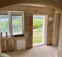 Interior of a family house with a view of the yard through open doors.