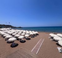 Sandy beach with sunbeds and umbrellas by the sea in Agia Eirini.
