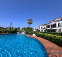 The pool and garden at the 2-bedroom apartments in the town of Agia Eirini on a sunny day.