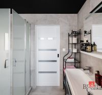 Bathroom in a 2-room apartment with a sink, shower, and a shelf for accessories.