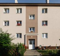 Apartment building in Zvolen on M. Bazovského Street with a colorful facade and a garden.