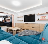 Living room with wood-patterned flooring and a blue sofa in a two-room apartment.