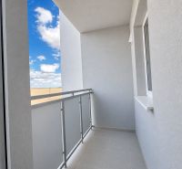 A balcony in a one-room apartment with a view of the sky and a clear blue color.