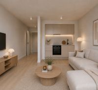 Living room of a studio apartment with wood-patterned flooring, a television, and a kitchenette.