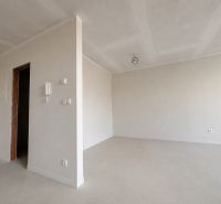 White interior of a 1-room apartment with an empty room and uninstalled light fixtures.