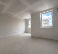 Unfurnished space in a one-room apartment with white walls and concrete floor.