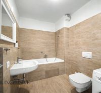 Bathroom in a 2-room apartment with a bathtub, sink, and washing machine, tiled.