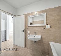 Bathroom in a 2-room apartment with beige tiles and an open door to the hallway.
