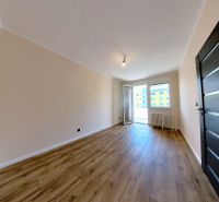 A room in a 3-room apartment with a wooden decor floor and access to a balcony.