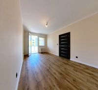 A bright room with wood-patterned flooring in a 3-room apartment.