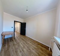 A room in a 3-room apartment with a wooden decor floor and a table.